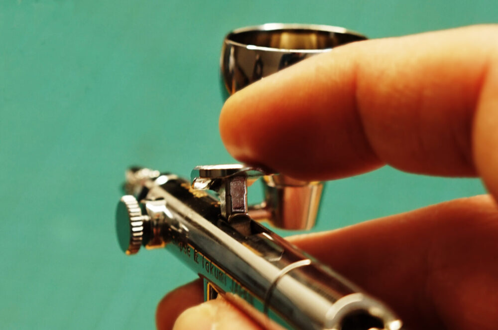 Airbrush-Pistole in der Hand, Nahaufnahme